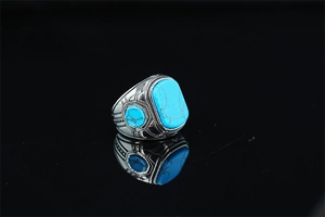 Macro shot of turquoise stones and tribal carvings on vintage silver-tone ring