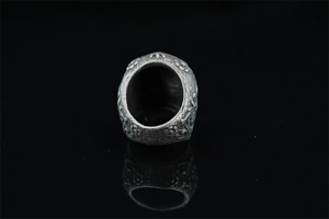 Macro detail of vintage skull ring featuring intricate floral embossed metal textures