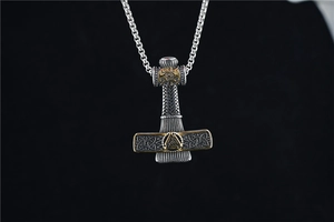 Détail du pendentif marteau de Thor Mjölnir viking avec symbole Valknut doré sur fond noir