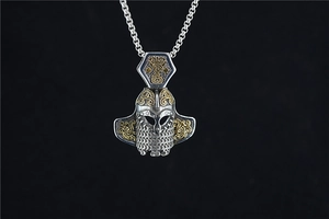Detail of Viking helmet pendant with dual-tone finish and intricate mesh texture on chain