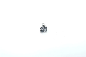 Macro shot of silver vintage suitcase pendant with Paris engraving and Eiffel Tower icon