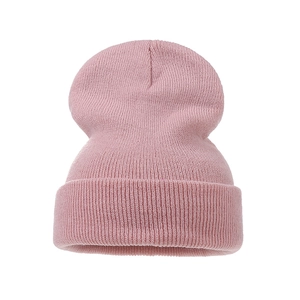 Detailed view of pink ribbed knit beanie with soft elastic texture and folded cuff