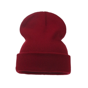 Close-up of dark red ribbed knit texture and folded cuff on a warm winter beanie hat