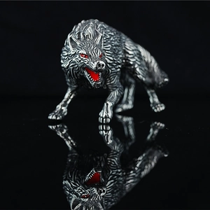 Heulende Wolfsfigur aus silbernem Edelstahl mit roten Augen auf schwarzem Grund