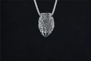 Macro shot of Viking wolf claw pendant with Valknut symbol and square box chain