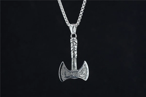 Détail d'un pendentif hache viking avec motif d'aigle en relief en argent vieilli