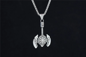 Close-up of vintage stainless steel Viking double axe pendant with Nordic rune details