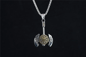 Detailed close-up of a vintage Viking double-headed axe pendant with runic gold center
