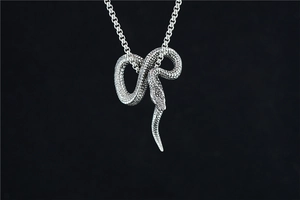 Détail d'un pendentif serpent 3D avec écailles ciselées et finition en argent rétro