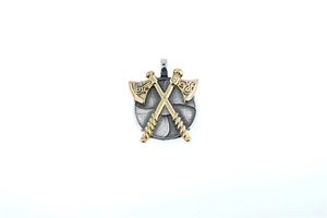 Macro detail of vintage viking pendant featuring crossed double axes on a circular shield