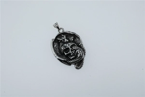 Détail macro d'un pendentif tête de mort gothique avec serpent en finition argent rétro