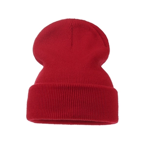 Detail view of the dense knit texture and elastic fabric of the red winter beanie