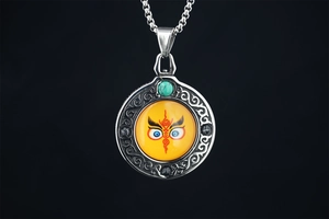 Macro detail of Tibetan Buddha Eyes pendant with turquoise bead and filigree metalwork