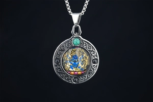 Macro detail of Buddhist pendant with turquoise bead and colorful deity icon in silver