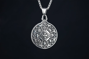 Macro detail of vintage silver mandala pendant with Buddhist symbols and cross vajra