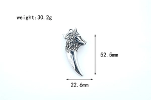Détail d'un pendentif dent de loup en acier argenté avec relief floral et finition vieillie