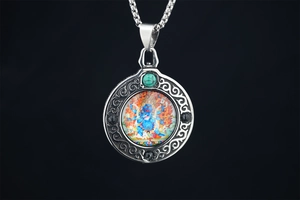 Macro shot of silver Thangka pendant featuring turquoise and intricate retro filigree