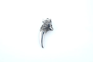 Détail macro du pendentif tête de loup avec finition antique sur chaîne longue en acier
