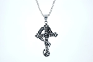 Dettaglio collana croce gotica con serpente intagliato e ciondolo teschio argento antico