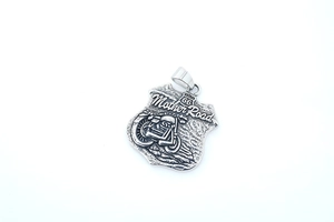Gros plan d'un pendentif bouclier moto vintage Route 66 en acier inoxydable patiné