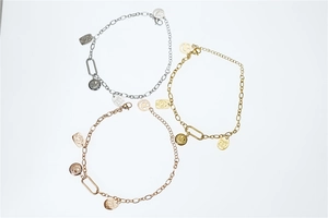 Detailed close-up of three smiley face charm bracelets in silver, gold, and rose gold finishes