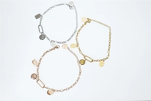 Close-up of gold, silver, and rose gold smile charm bracelets with metal engraving