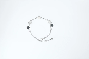 Detail of minimalist double-layer chain bracelet featuring round geometric charms and lobster clasp