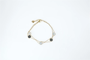 Detail of gold double-layer bracelet with black and white circular shell pendants