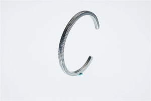Dettaglio del bracciale aperto in argento con trama a spina di pesce molto definita