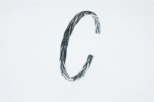 Dettaglio della trama a corda intrecciata vintage sul bracciale rigido in acciaio titanio