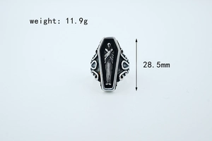 Macro view of gothic coffin ring showing carved figure and ornate floral scrollwork