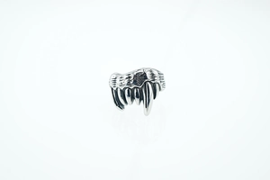 Detail of vintage punk wolf tooth ring with oxidized titanium steel texture and Gothic design
