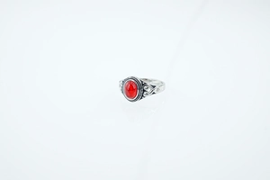 Detailed close-up of retro silver ring featuring a red oval gemstone and Celtic knot design