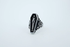 Macro view of gothic punk coffin ring with relief reaper figure and vintage textures