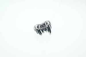 Macro detail of silver punk wolf fang ring showing vintage gothic metallic texture