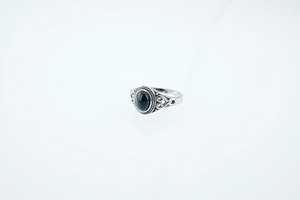 Detailed close-up of retro silver ring featuring black oval stone and Celtic patterns