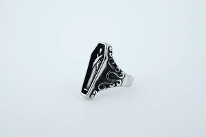 Detailed view of punk coffin ring with relief figure and vintage floral carvings
