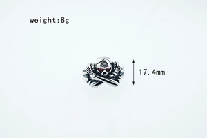 Macro d'une bague crâne en argent avec yeux en pierre rouge et détails de mesure de taille