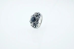 Détail d'une bague tête de mort gothique avec gemme noire ovale et finition acier vintage