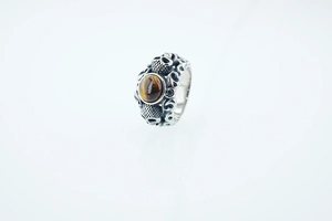 Macro de la bague crâne vintage avec pierre œil de tigre ronde et motifs gothiques