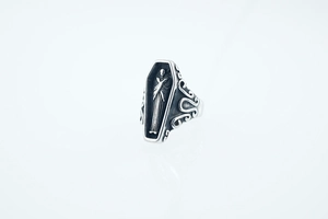 Macro detail of gothic coffin ring featuring engraved figure and vintage oxidized finish