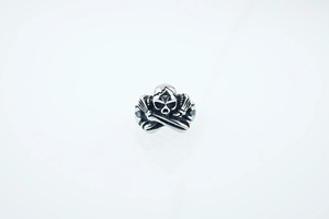 Détail de la bague gothique tête de mort avec os croisés et finition argentée vintage