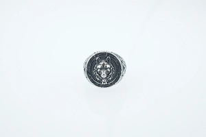 Detailed close-up of a vintage wolf head relief on a men's stainless steel biker ring