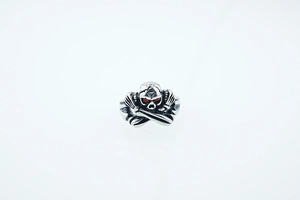 Détail d'une bague tête de mort vintage avec yeux rouges et finitions en argent vieilli