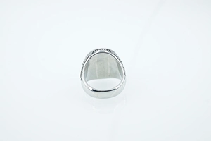 Detailed view of vintage wolf head ring with intricate floral engraving on polished steel