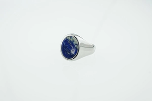 Macro shot of silver signet ring with oval blue lapis lazuli stone inlay on white background