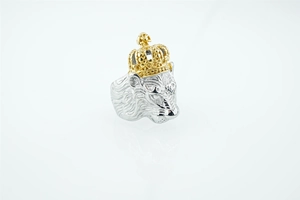 Detailed close-up of a punk style lion head ring with a gold crown and silver mane