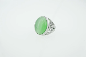 Détail d'une bague vintage avec pierre oeil de chat verte ovale et ciselures florales