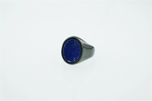 Macro detail of men's titanium ring with oval lapis lazuli stone in dark grey metal