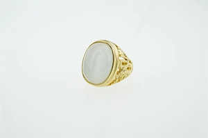 Vue détaillée de la bague en or vintage avec pierre blanche ovale et gravures ajourées fines